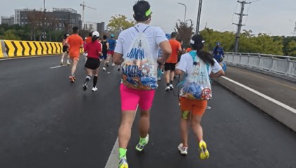 苏州马拉松一男一女将给选手的免费零食打包“负重”奔跑?主办方回应